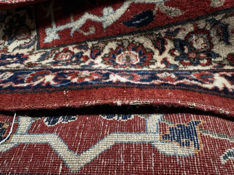 Before binding repair: the worn side edge of a Persian rug with its foundation exposed
